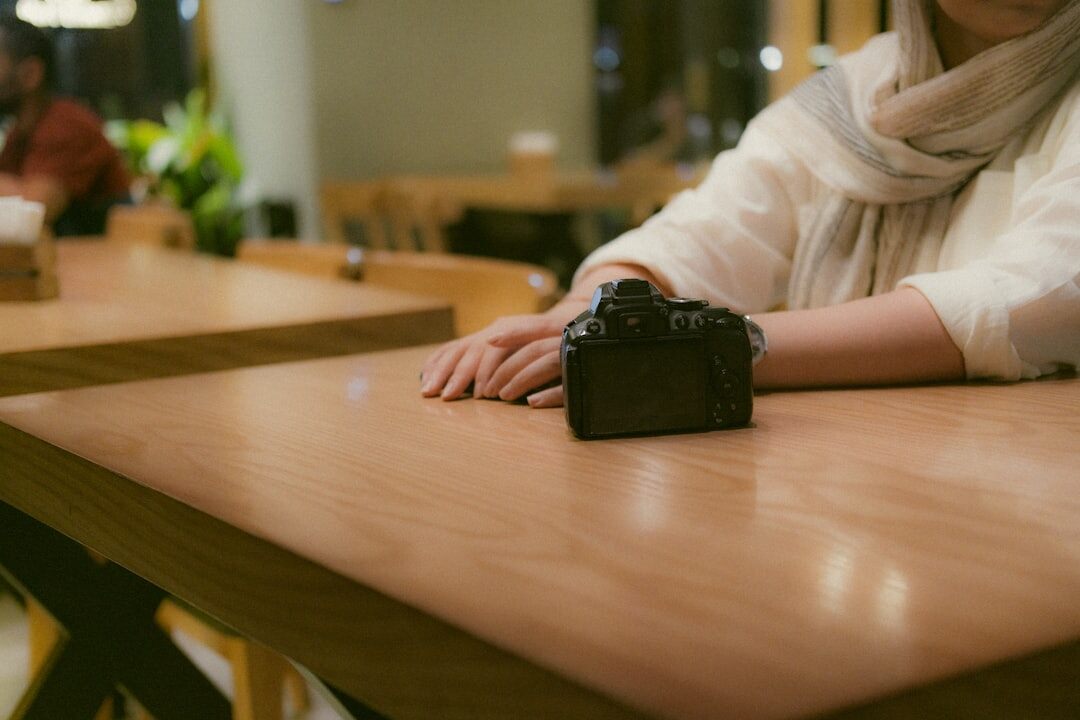 Camera and press pass on a wooden desk